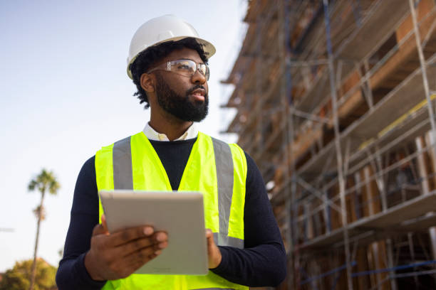 A young black man is a project manager at a residential construction site.